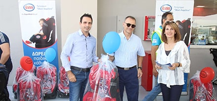 Three people at an event smiling to camera with free children’s car seats